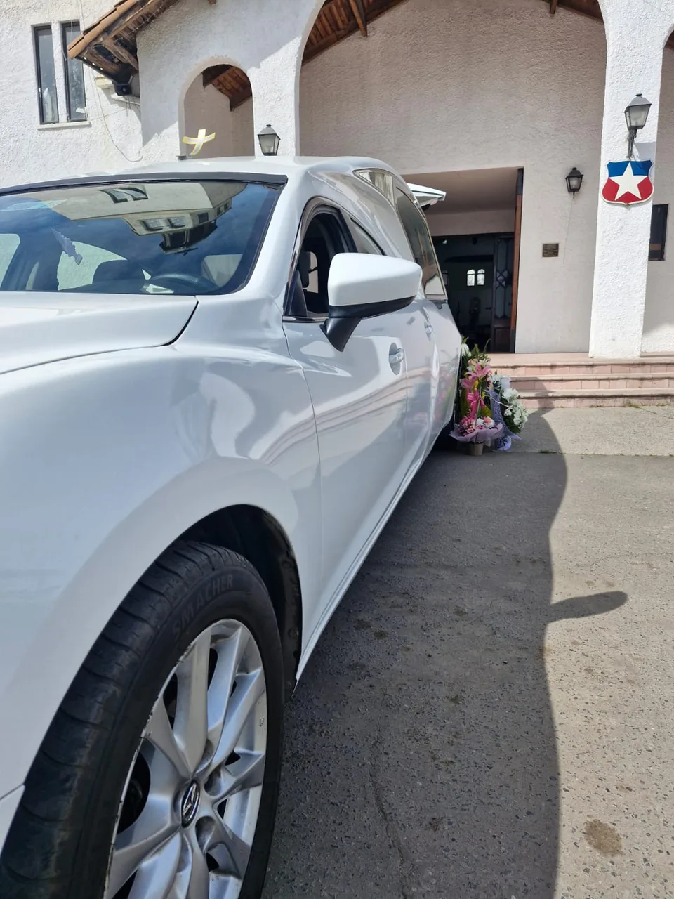 Detalle de una carroza blanca frente a una iglesia